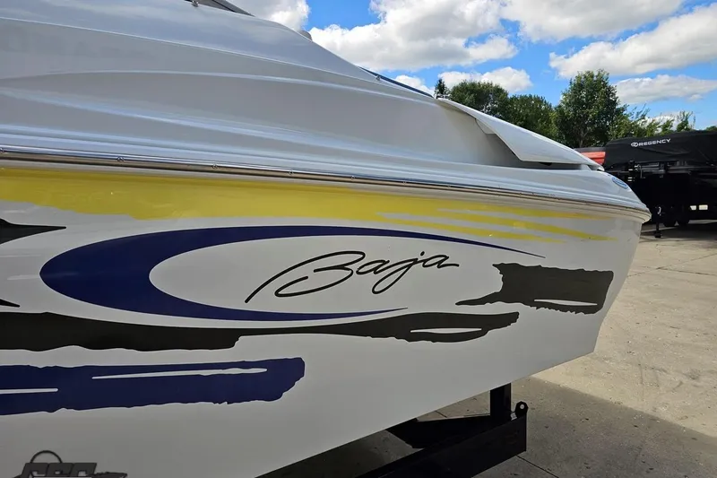 Slide: The Image of 2005 Baja 275 boat with colorful graphics, parked outdoors under a blue sky. - 23