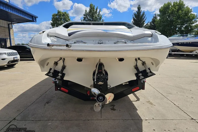 Slide: The Image of 2005 Baja 275 boat on trailer, rear view, parked outdoors under blue sky. - 27