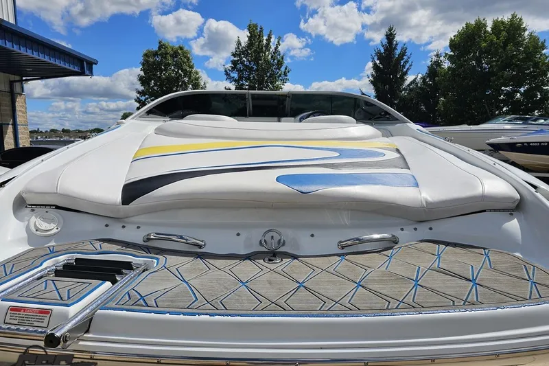 Slide: The Image of 2005 Baja 275 boat with colorful deck design, docked under a partly cloudy sky. - 29