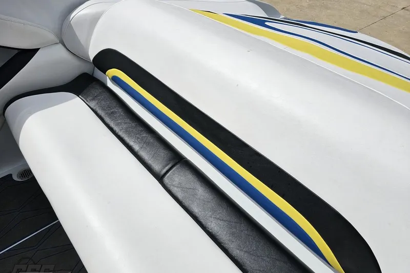 Slide: The Image of 2005 Baja 275 boat interior with white, black, yellow, and blue upholstery design. - 47