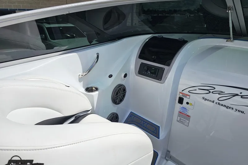 Slide: The Image of Interior of a 2005 Baja 275 boat with white seating and control panel. - 58