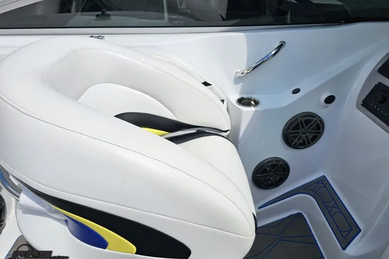Slide: The Image of White leather seat in 2005 Baja 275 boat interior, featuring speakers and cup holder. - 60