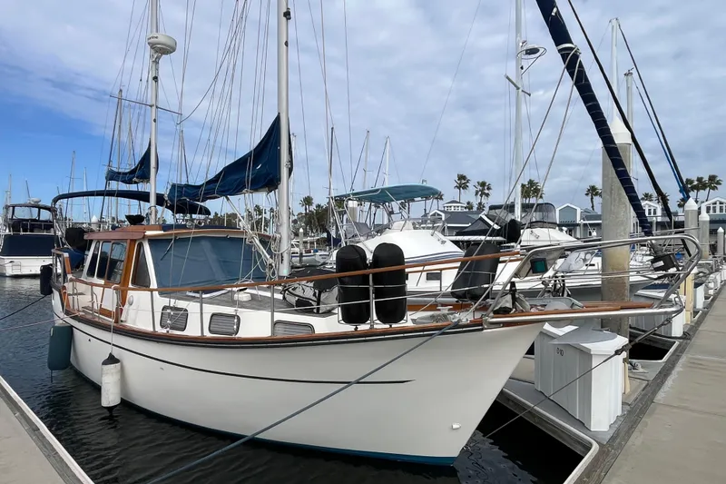 The Image of 1986 Nauticat 33' sailboat docked at marina under cloudy sky. - 0