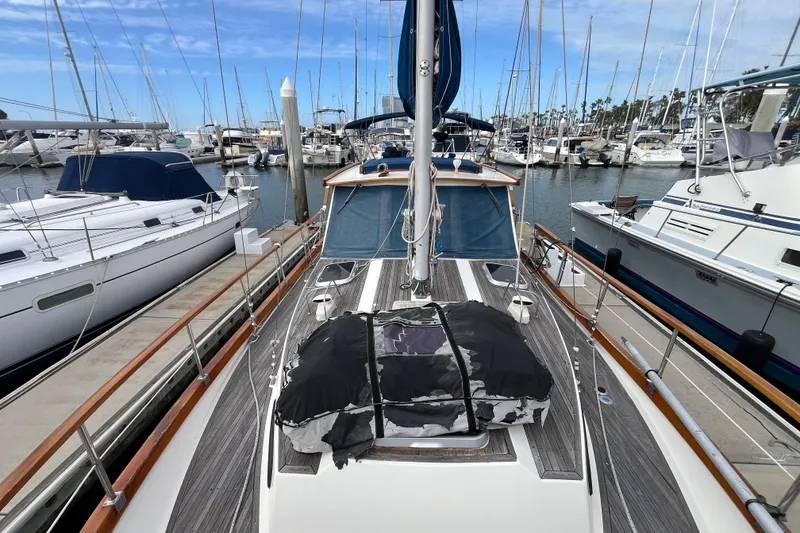 Slide: The Image of 1986 Nauticat 33' sailboat docked in a marina, surrounded by other boats. - 10