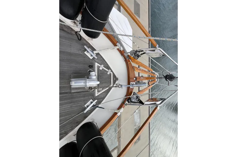 Slide: The Image of Bow view of 1986 Nauticat 33' sailboat with wooden deck and metal fittings. - 12