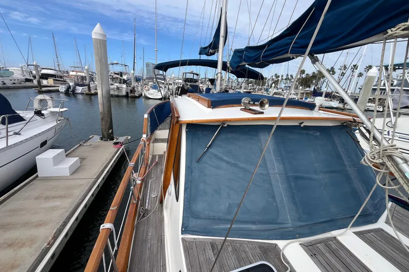 Slide: The Image of 1986 Nauticat 33' sailboat docked at marina, featuring blue canvas covers and wooden deck. - 14