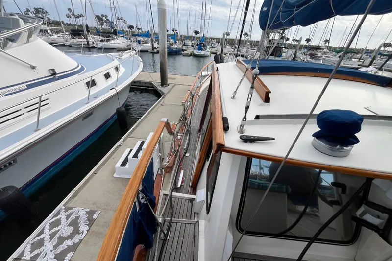 Slide: The Image of 1986 Nauticat 33' sailboat docked in a marina, surrounded by other boats. - 22