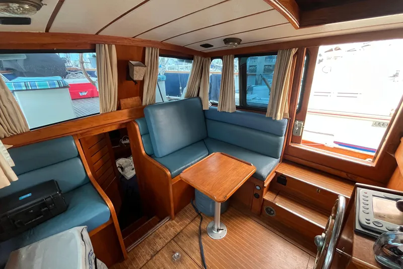 Slide: The Image of Interior of 1986 Nauticat 33' sailboat with blue seating and wooden table. - 24