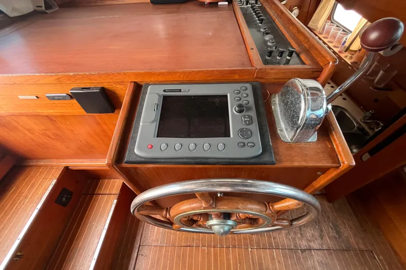 Slide: The Image of Helm of 1986 Nauticat 33' sailboat with navigation equipment and wooden steering wheel. - 26