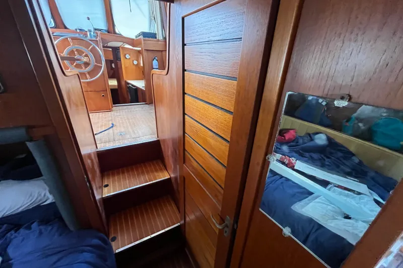 Slide: The Image of Interior of 1986 Nauticat 33' sailboat with wooden stairs and cozy cabin. - 34