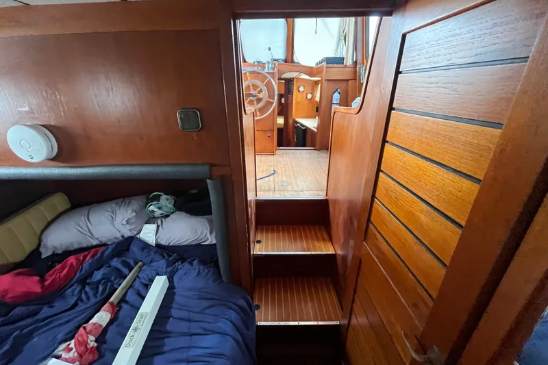 Slide: The Image of Interior of 1986 Nauticat 33' sailboat with wooden stairs and cozy sleeping area. - 35