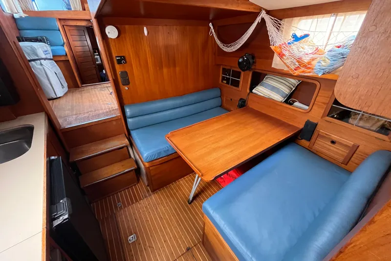 Slide: The Image of Cozy interior of 1986 Nauticat 33' sailboat with wooden furnishings and blue seating. - 41