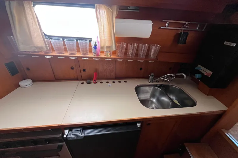 Slide: The Image of Compact kitchen area in a 1986 Nauticat 33' sailboat with sink and storage. - 48