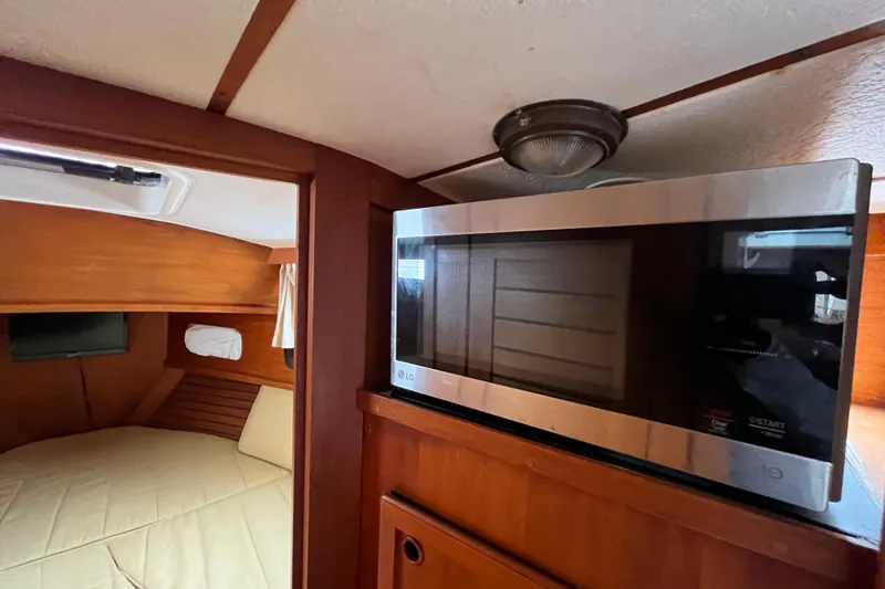 Slide: The Image of Interior of 1986 Nauticat 33' yacht with microwave and cozy cabin space. - 49