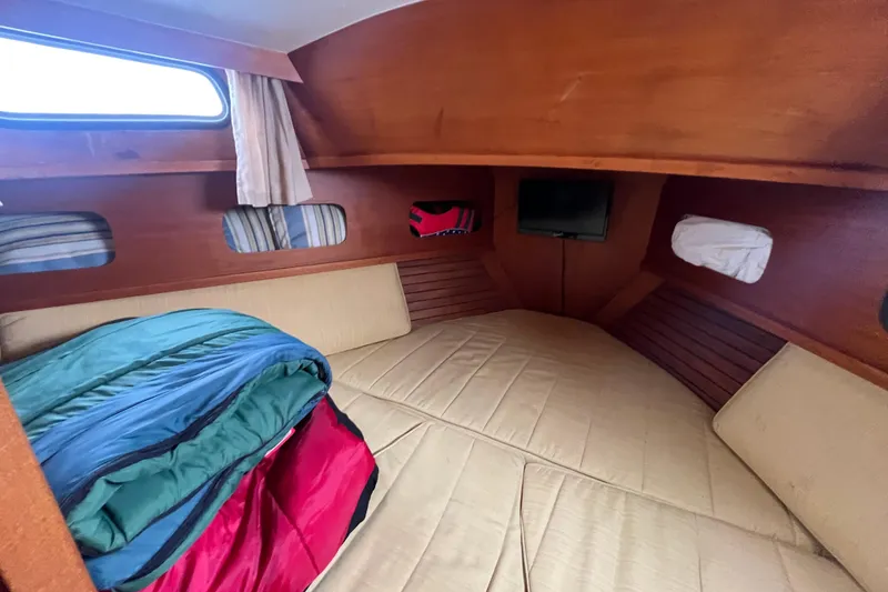 Slide: The Image of Cozy cabin interior of 1986 Nauticat 33' sailboat with bedding and porthole. - 52