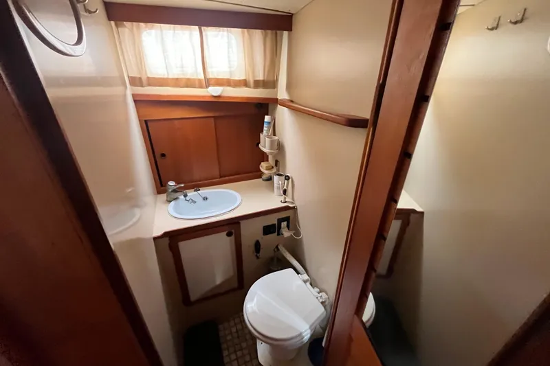 Slide: The Image of 1986 Nauticat 33' yacht bathroom with sink, toilet, and wooden cabinetry. - 55