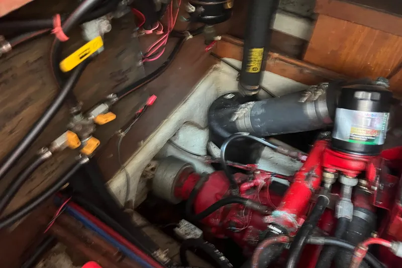 Slide: The Image of Engine compartment of a 1986 Nauticat 33' sailboat, showing wiring and mechanical components. - 59