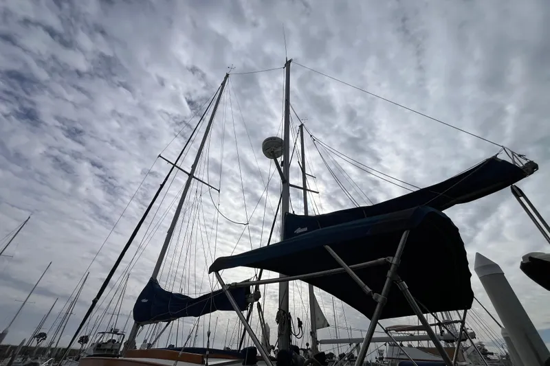 Slide: The Image of 1986 Nauticat 33' sailboat with masts against a cloudy sky. - 6