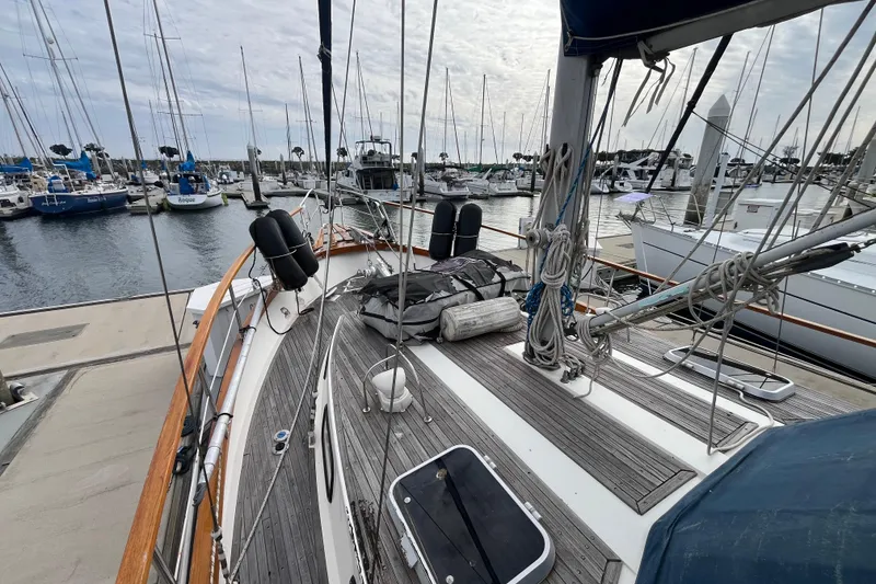 Slide: The Image of 1986 Nauticat 33' sailboat docked in a marina, surrounded by other boats. - 9