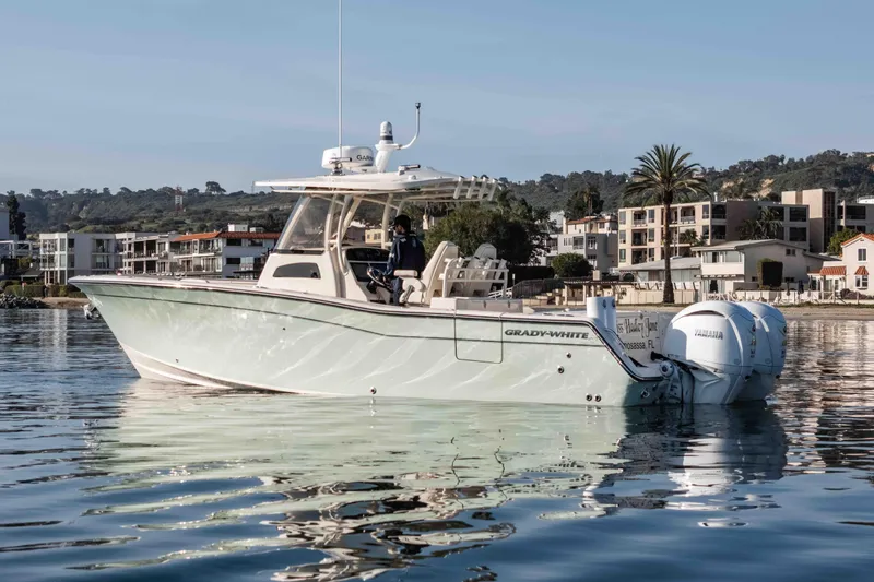 Slide: The Image of 2022 Grady-White Canyon 306 boat on calm water near modern waterfront homes. - 10