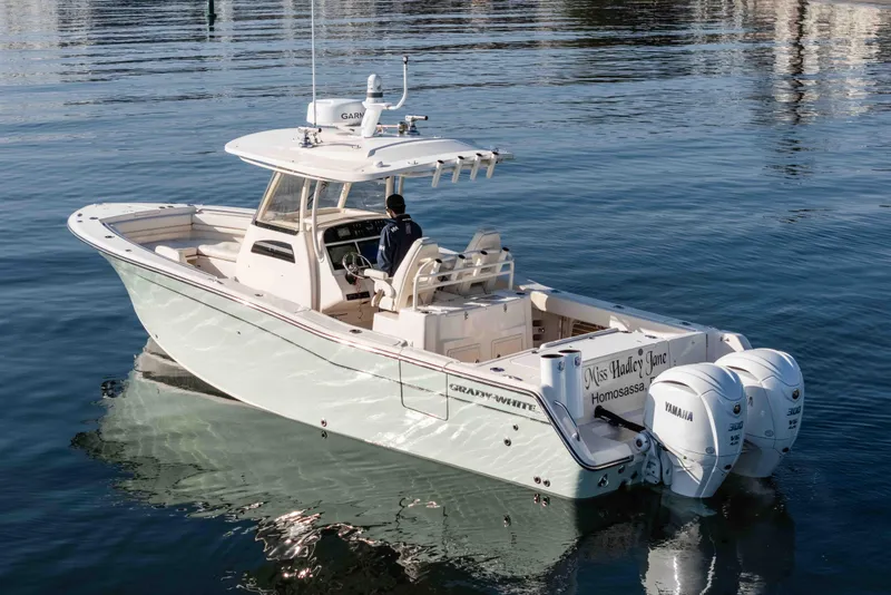 Slide: The Image of 2022 Grady-White Canyon 306 boat on calm water, featuring dual Yamaha engines. - 11