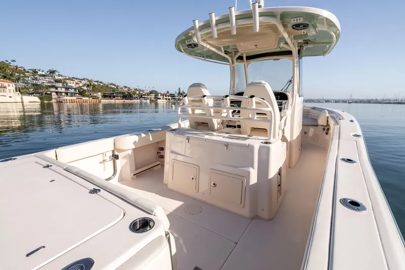 Slide: The Image of 2022 Grady-White Canyon 306 boat on calm water, showcasing spacious deck and seating. - 17