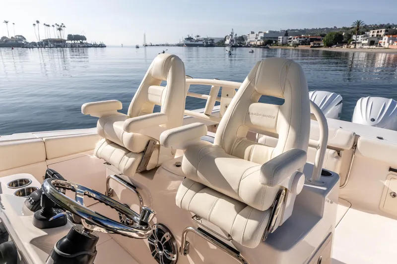 Slide: The Image of 2022 Grady-White Canyon 306 boat interior with luxurious seating and scenic harbor view. - 22