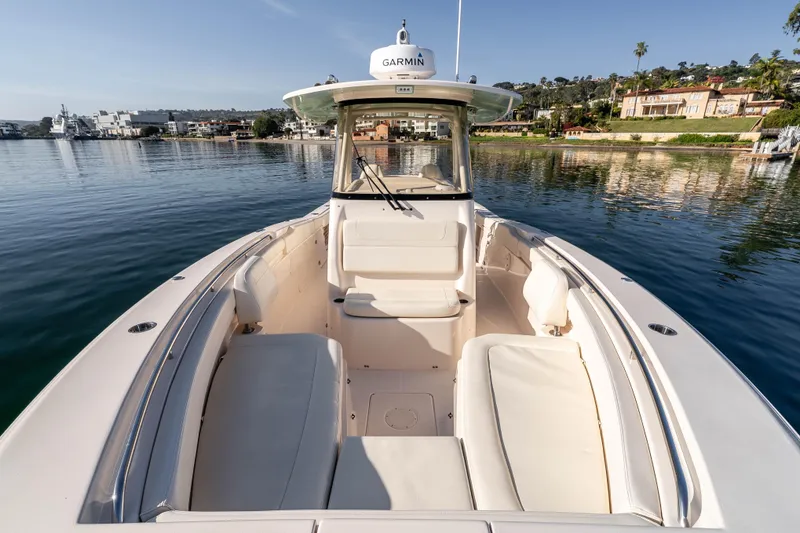 Slide: The Image of 2022 Grady-White Canyon 306 boat on calm water, featuring spacious seating and Garmin equipment. - 24