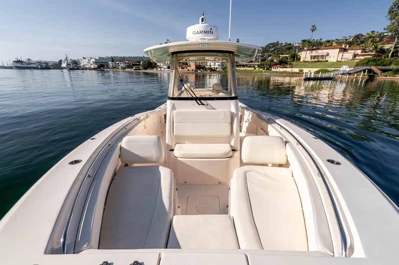 Slide: The Image of 2022 Grady-White Canyon 306 boat on calm water, featuring spacious seating and Garmin equipment. - 25