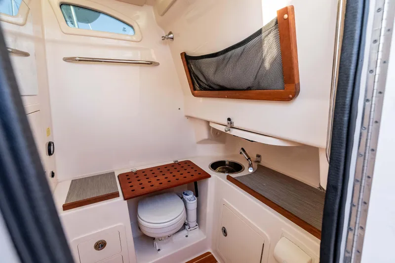 Slide: The Image of 2022 Grady-White Canyon 306 boat interior with compact bathroom and sink. - 26