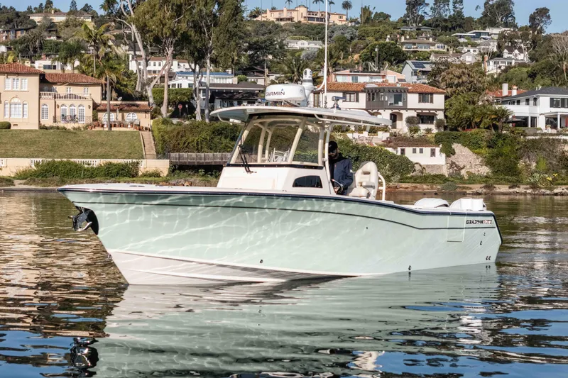 Slide: The Image of 2022 Grady-White Canyon 306 boat on calm water near luxury waterfront homes. - 8