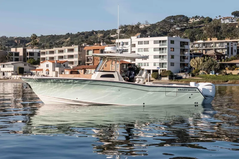 Slide: The Image of 2022 Grady-White Canyon 306 boat on calm water near coastal buildings. - 9