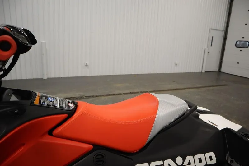 Slide: The Image of 2025 Sea-Doo Spark Trixx for 1, vibrant orange seat, indoor setting. - 15