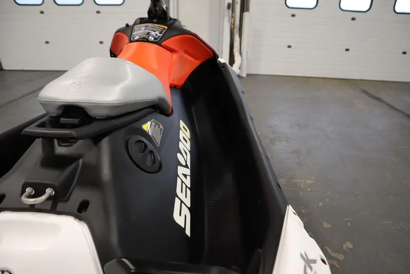 Slide: The Image of 2025 Sea-Doo Spark Trixx for 1, black and orange, in a garage setting. - 17