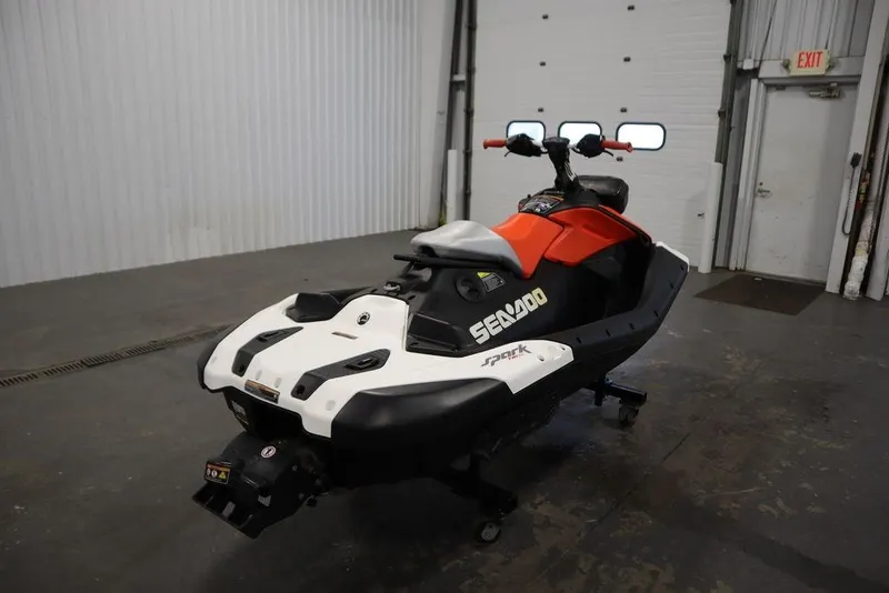 Slide: The Image of 2025 Sea-Doo Spark Trixx for 1 in a garage setting, showcasing sleek design. - 5