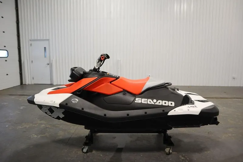 Slide: The Image of 2025 Sea-Doo Spark Trixx for 1, red and black, in a garage setting. - 6