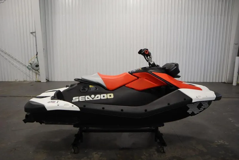 Slide: The Image of 2025 Sea-Doo Spark Trixx for 1, black and red, in a garage setting. - 7
