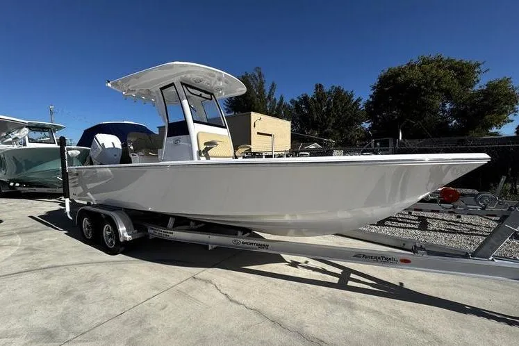 The Image of 2026 Sportsman Masters 247OE Bay Boat on trailer, parked outdoors under clear blue sky. - 1