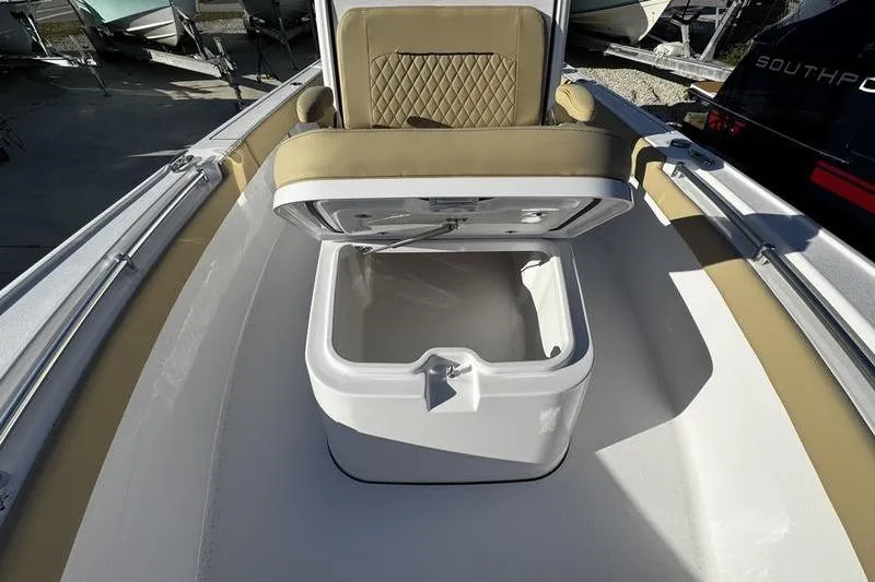 Slide: The Image of 2026 Sportsman Masters 247OE Bay Boat with open storage compartment and cushioned seating. - 12