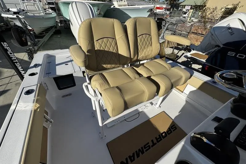 Slide: The Image of 2026 Sportsman Masters 247OE Bay Boat with tan cushioned seating and modern design. - 13