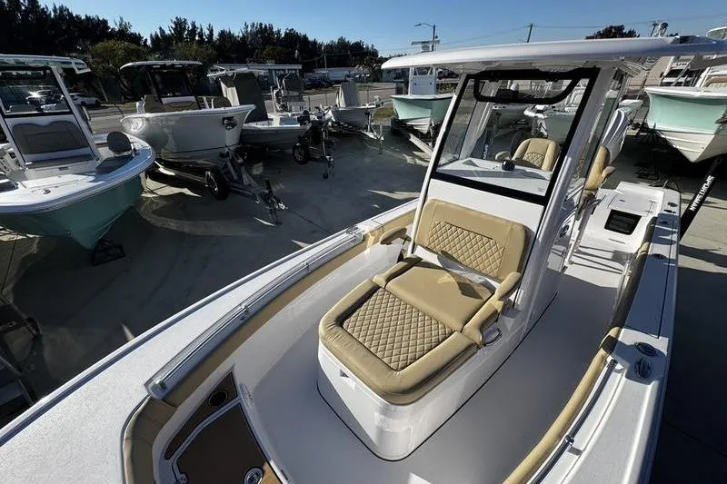 Slide: The Image of 2026 Sportsman Masters 247OE Bay Boat with tan seating, displayed in a marina setting. - 15
