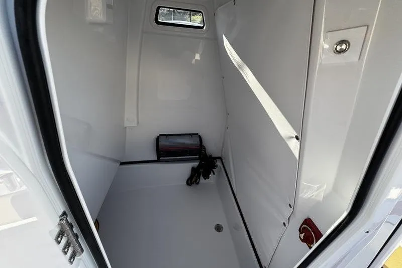 Slide: The Image of 2026 Sportsman Masters 247OE Bay Boat interior storage compartment, white and spacious. - 22