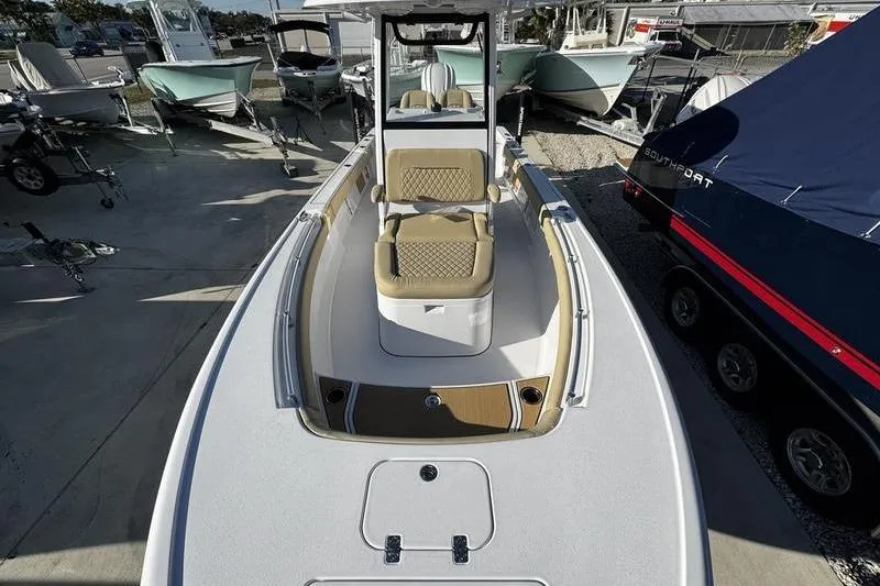 Slide: The Image of 2026 Sportsman Masters 247OE Bay Boat with tan seating, docked among other boats. - 3