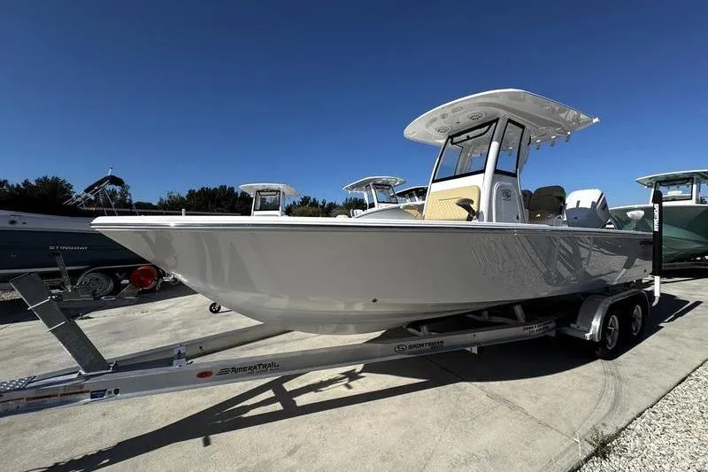 Slide: The Image of 2026 Sportsman Masters 247OE Bay Boat on trailer, sleek design under clear blue sky. - 5