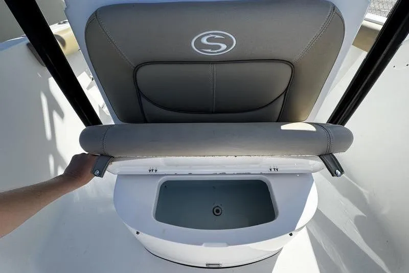 Slide: The Image of 2026 Sportsman Open 232 Center Console boat seat with storage compartment open. - 12