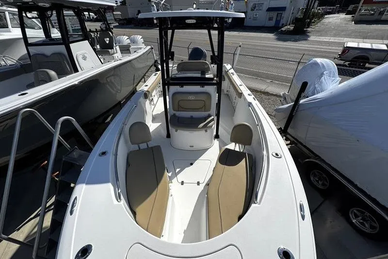 Slide: The Image of 2026 Sportsman Open 232 Center Console boat with seating and console, docked outdoors. - 4