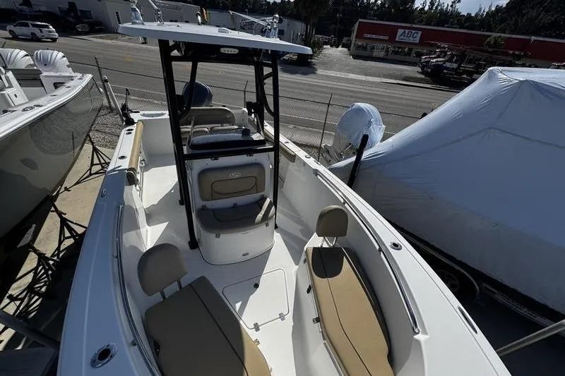 Slide: The Image of 2026 Sportsman Open 232 Center Console boat with seating, docked outdoors. - 7