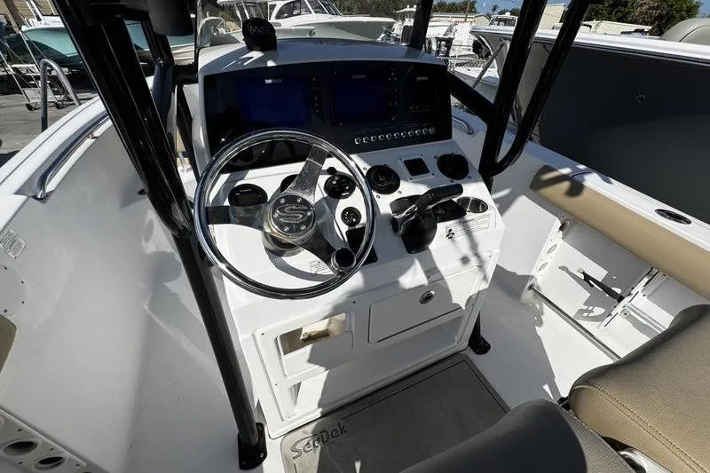Slide: The Image of 2026 Sportsman Open 232 Center Console boat cockpit with steering wheel and controls. - 16