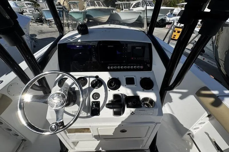 Slide: The Image of 2026 Sportsman Open 232 Center Console boat dashboard with steering wheel and controls. - 17