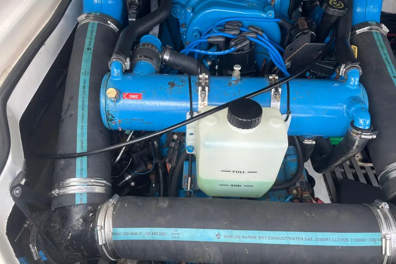 Slide: The Image of Engine compartment of a 1998 Tiara Yachts 2900 Coronet, featuring blue components and hoses. - 14
